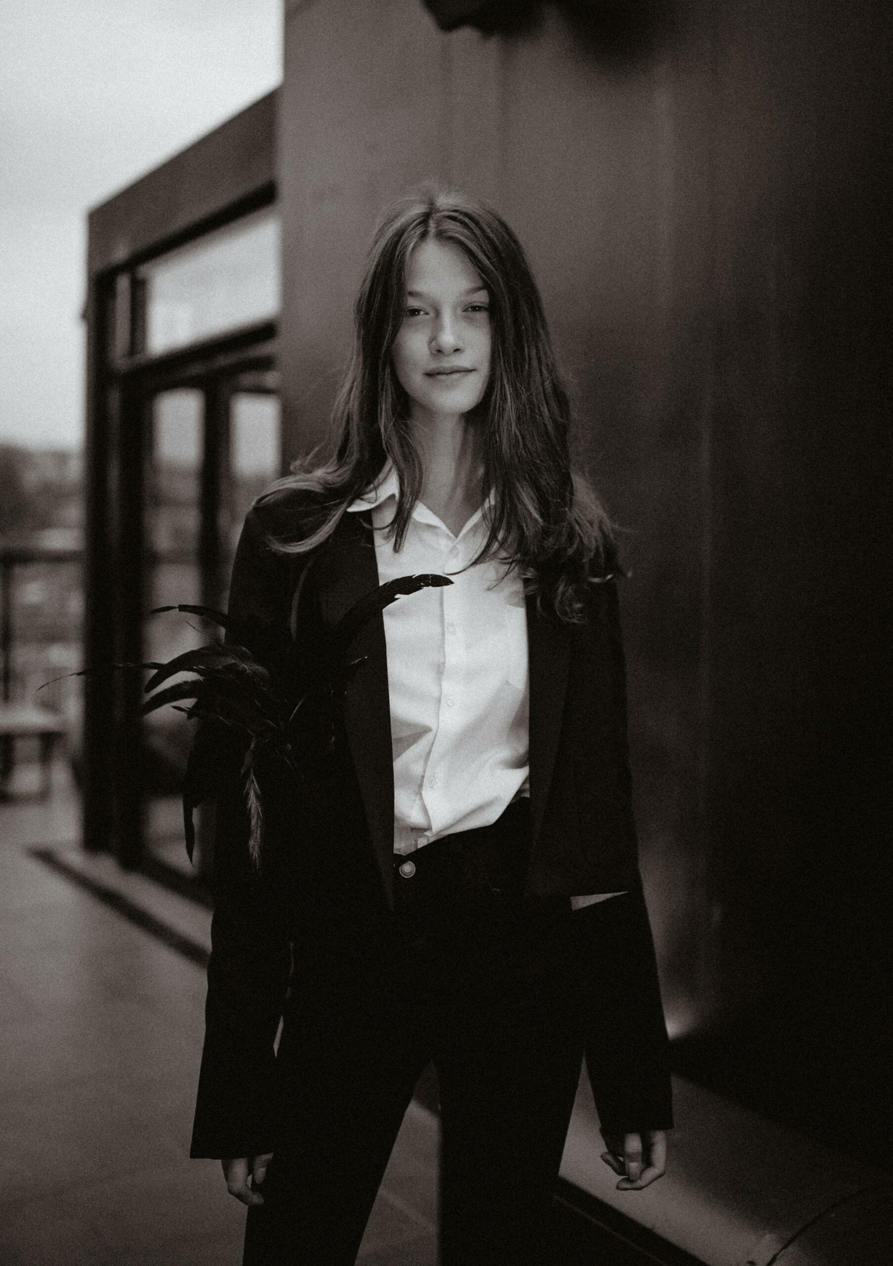 Elegant black and white portrait of a young woman in a stylish outfit, exuding a classic and timeless aura.